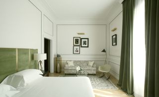 Palazzo Dama bedroom with green curtains and headboard with brass trim, Persian carpet