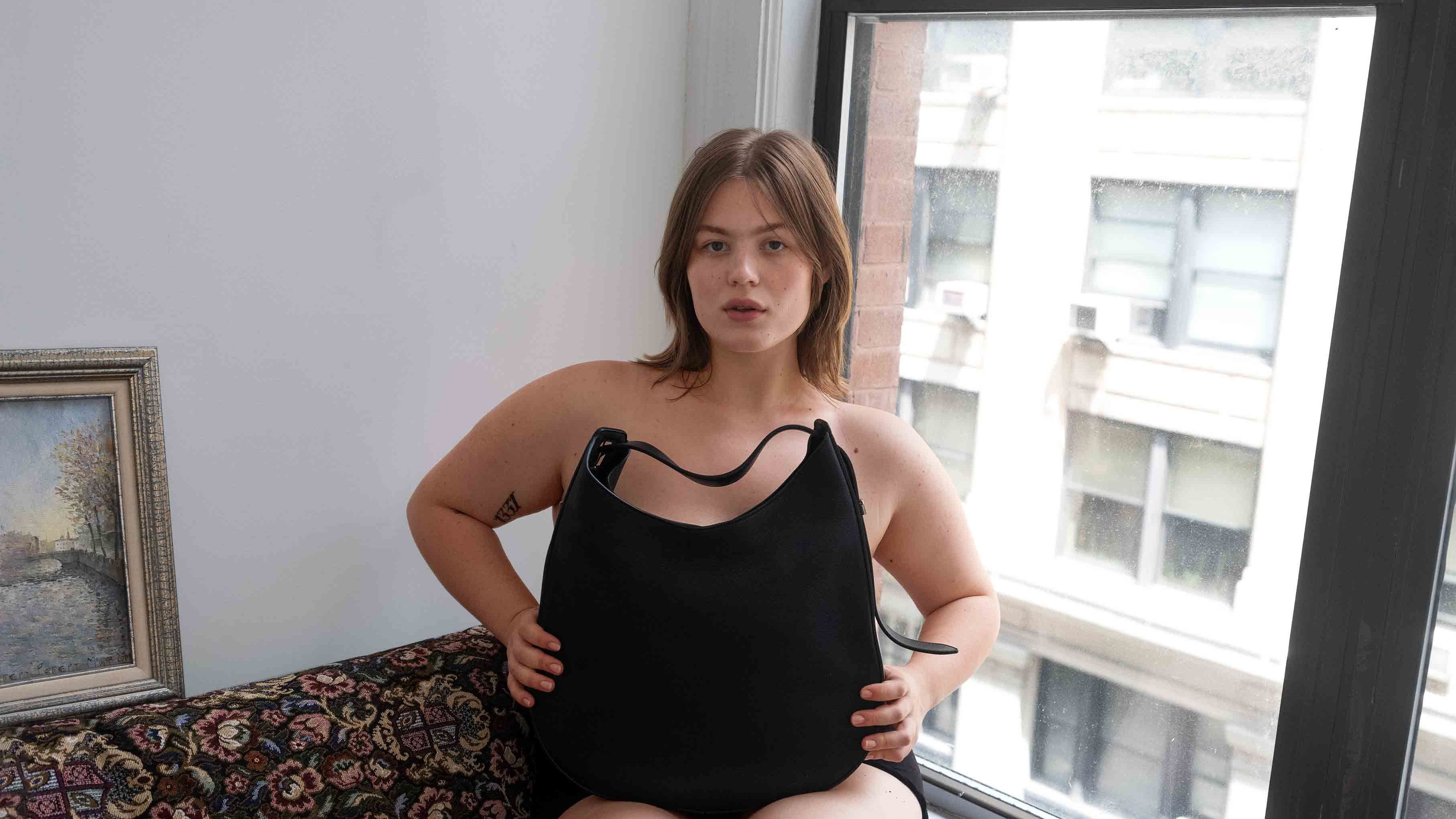 Model with large handbag on lap