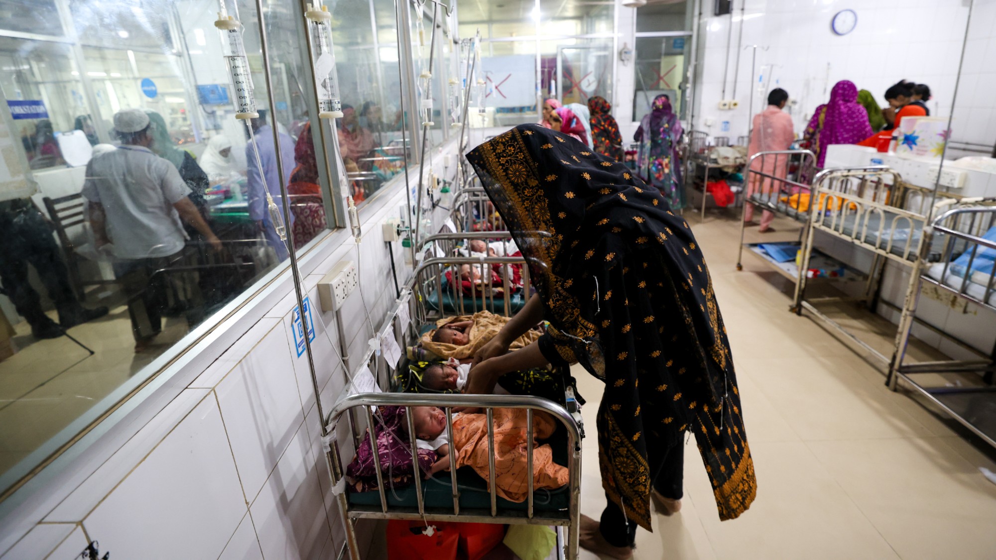 A women watches over newborn children at a hospital in Barishal, Bangladesh. 