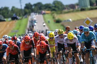 UAE Team Emirates team's Slovenian rider Tadej Pogacar wearing the overall leader's yellow jersey (C) cycles with the pack of riders (peloton) during the 6th stage of the 111th edition of the Tour de France cycling race, 163,5 km between Macon and Dijon, on July 4, 2024. (Photo by Thomas SAMSON / AFP)