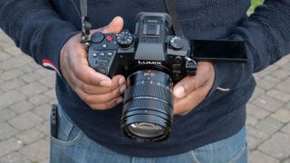 Panasonic Lumix GH6 held in a mans hands outside