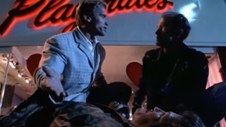 Arnold Schwarzenegger tends to an injured man in Twins