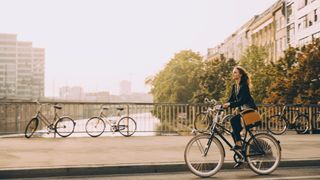 Woman cycling on empty road in the city, one example of LISS cardio training
