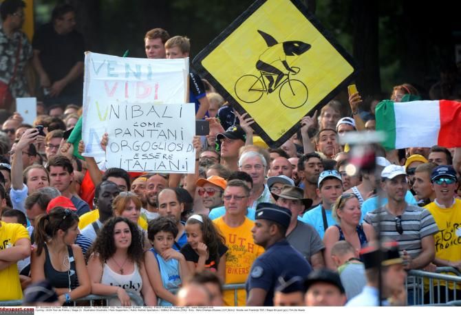 A shark in yellow riding a bike of course
