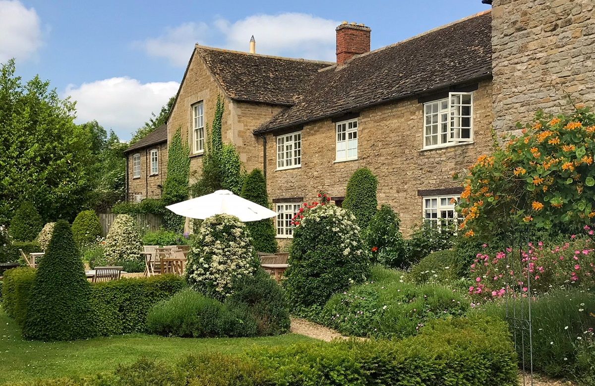 Pretty stone house surrounded by lush gardens