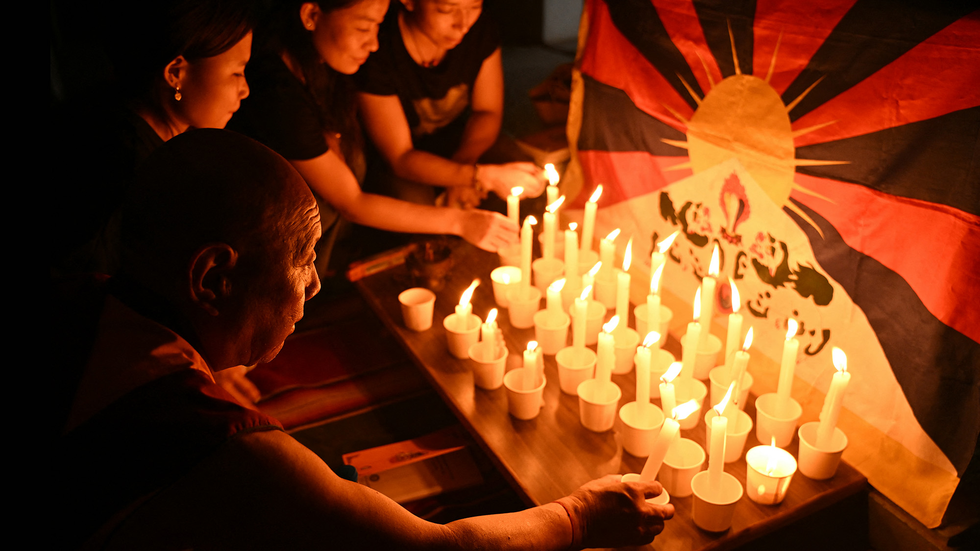People light candles during a prayer gathering to mark the Tibetan uprising anniversary, in Chennai, India