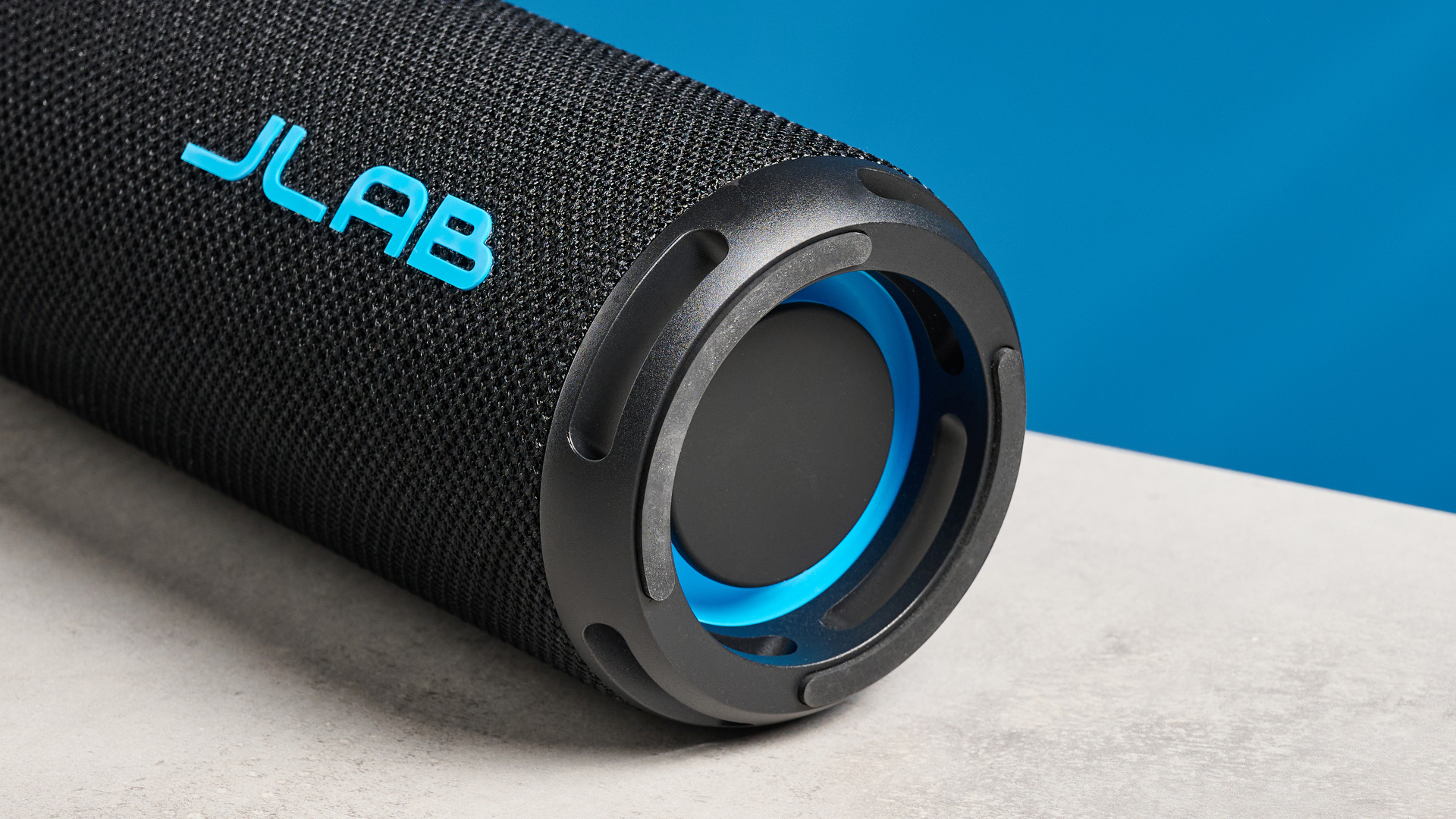 the jlab go party speaker in black with an LED RGB panel and jlab logo photographed in front of a blue background