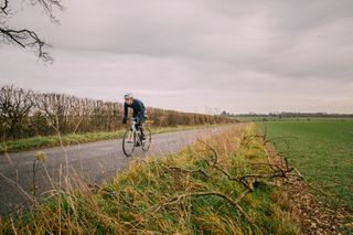Image shows cyclist riding into a headwind