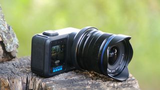 The GoPro Mission 1 ILS mirrorless camera photographed outdoors on a tree stump