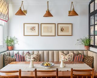 Small dining room with banquette seating and row of three rattan pendants