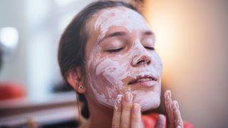 a woman putting on a face mask