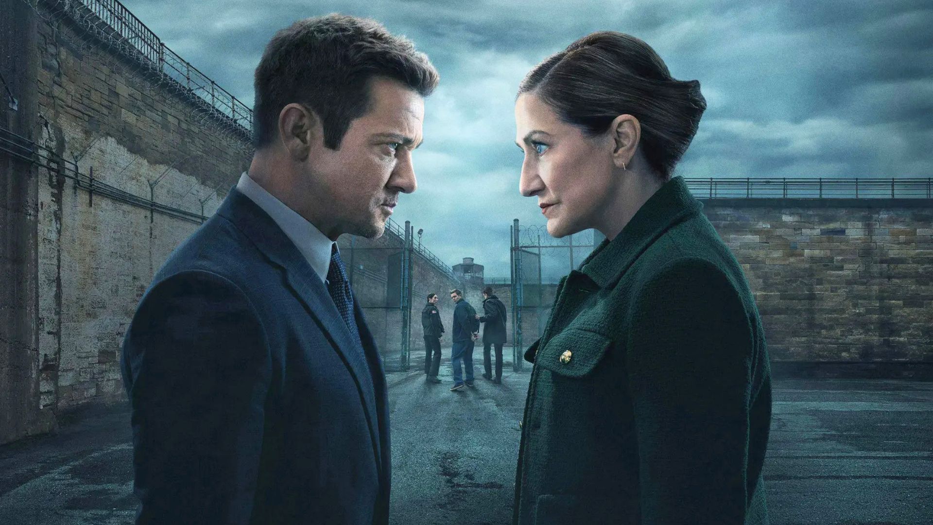 A man and a woman look at each other outside prison gates