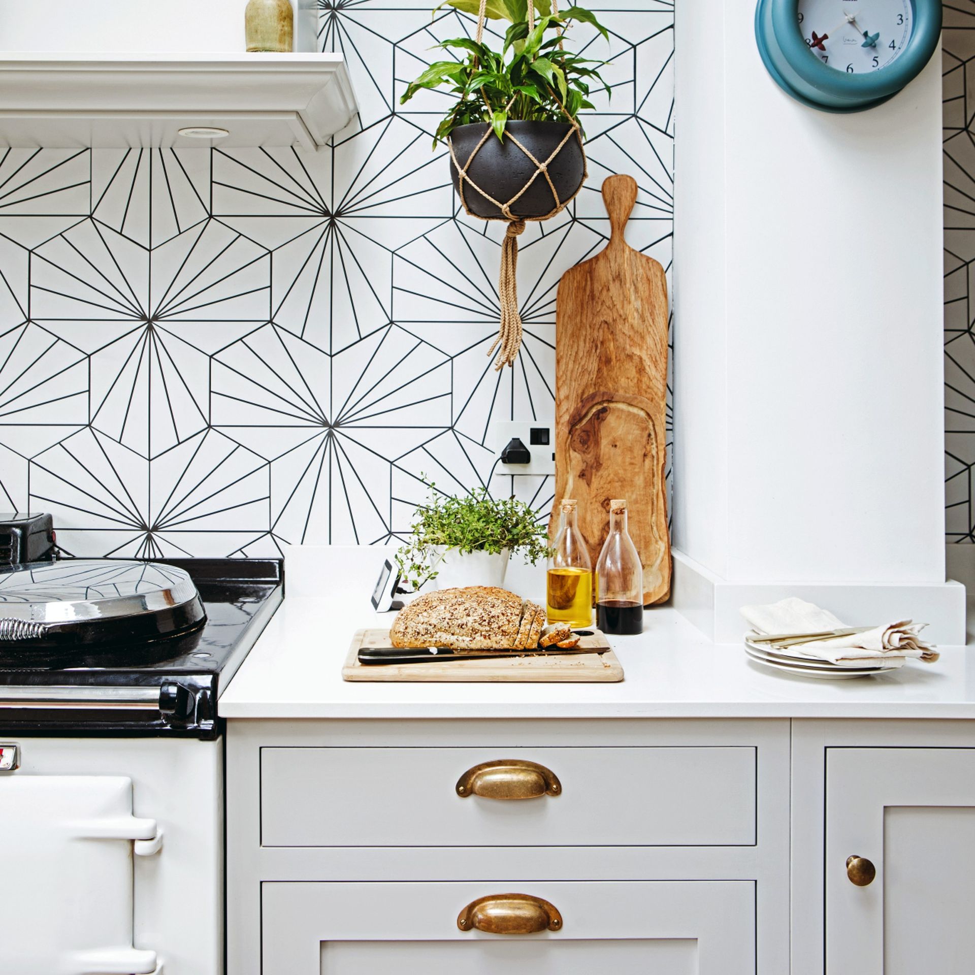 Kitchen counter and cabinets with gold handles, wooden chopping board