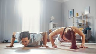 Man and woman perform press-ups at home