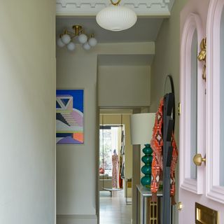 Hallway with an open front pink door, high ceiling and diamond pattern flooring
