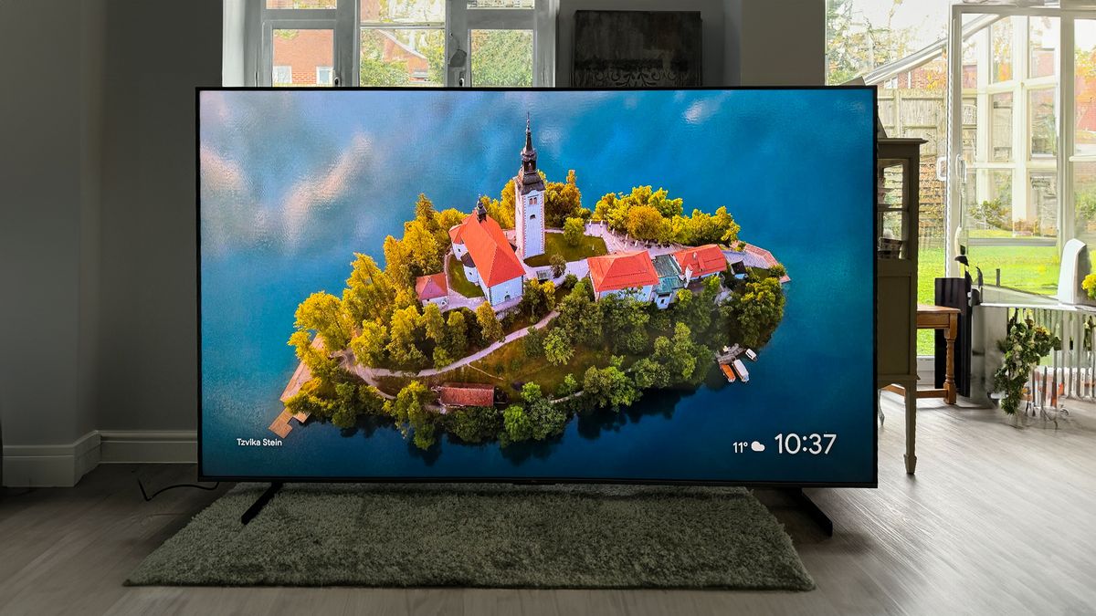 TCL 98Q9BK Mini LED TV on floor of living room showing island with church on screen