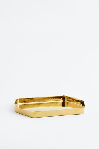 gold-tone hexagonal trinket tray laying on a flat surface
