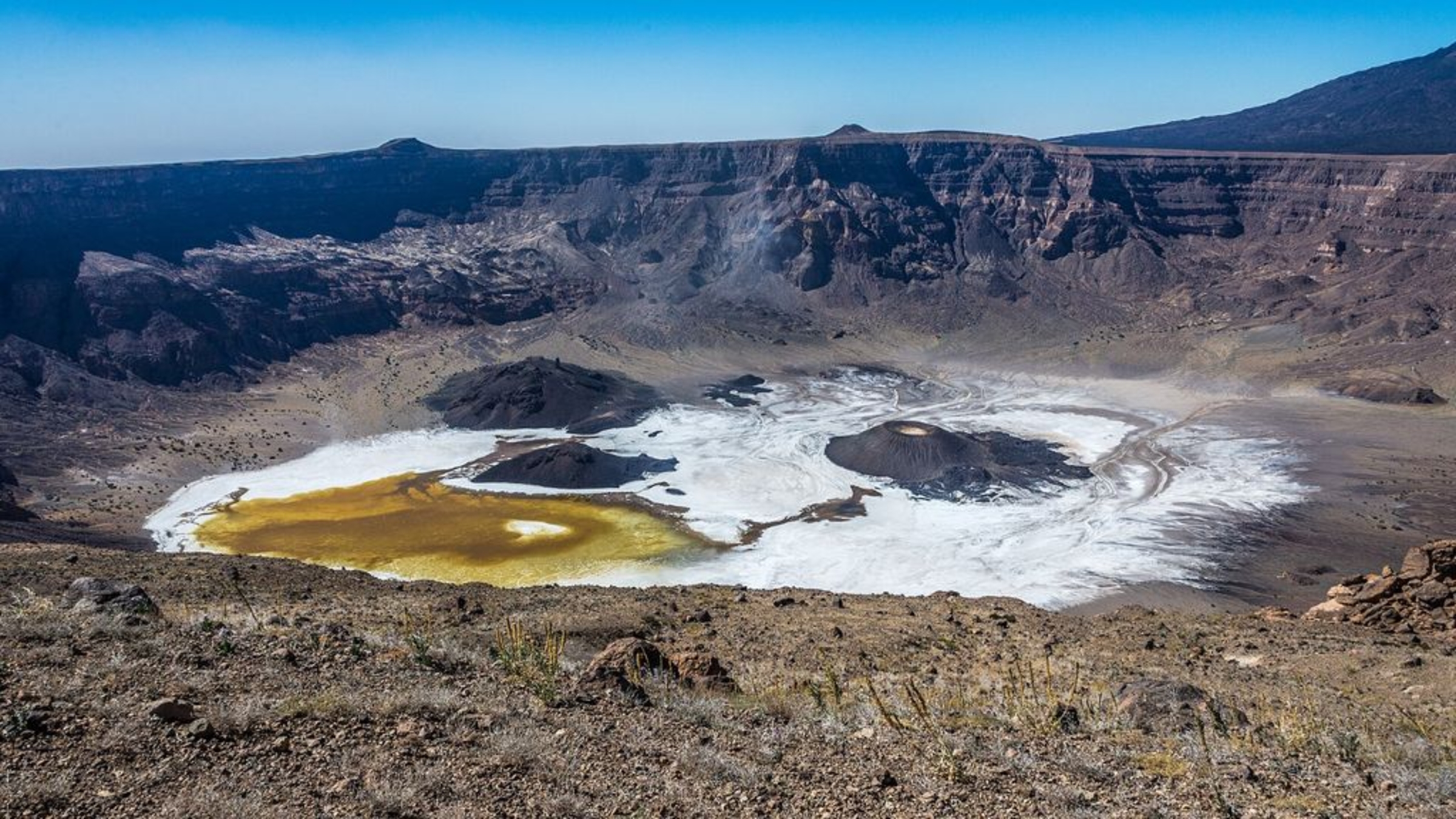 A photo of the Trou au Natron caldera taken from the crater rim, showing off its salty white floor