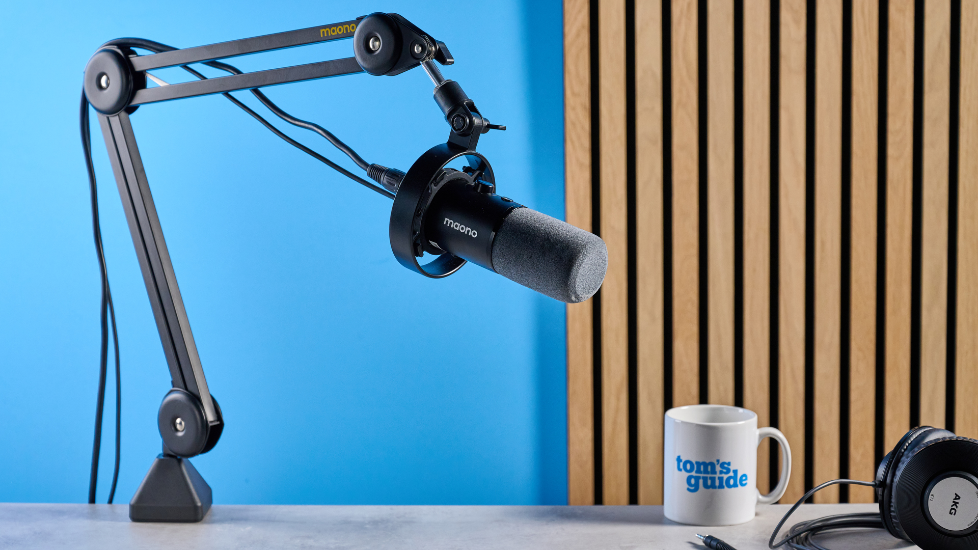 the maono pd300x microphone for podcasting with an xlr and usbc connection and a boom arm in the photograph but also available with a desktop stand, one button dial on the mic and a muting button 