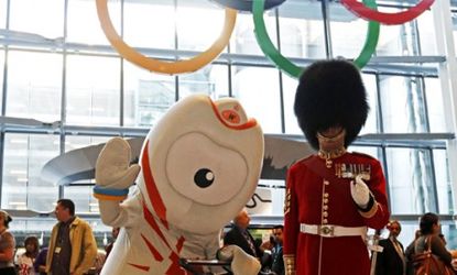 Olympic mascot Wenlock poses next to a British royal guard under the newly revealed Olympic rings in Heathrow Airport: The total cost of the London Olympics, including the cost of security, c