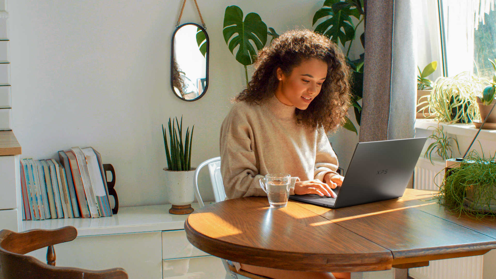 Dell Pro laptop being used by a person sat at a table in a well-lit room, working from home
