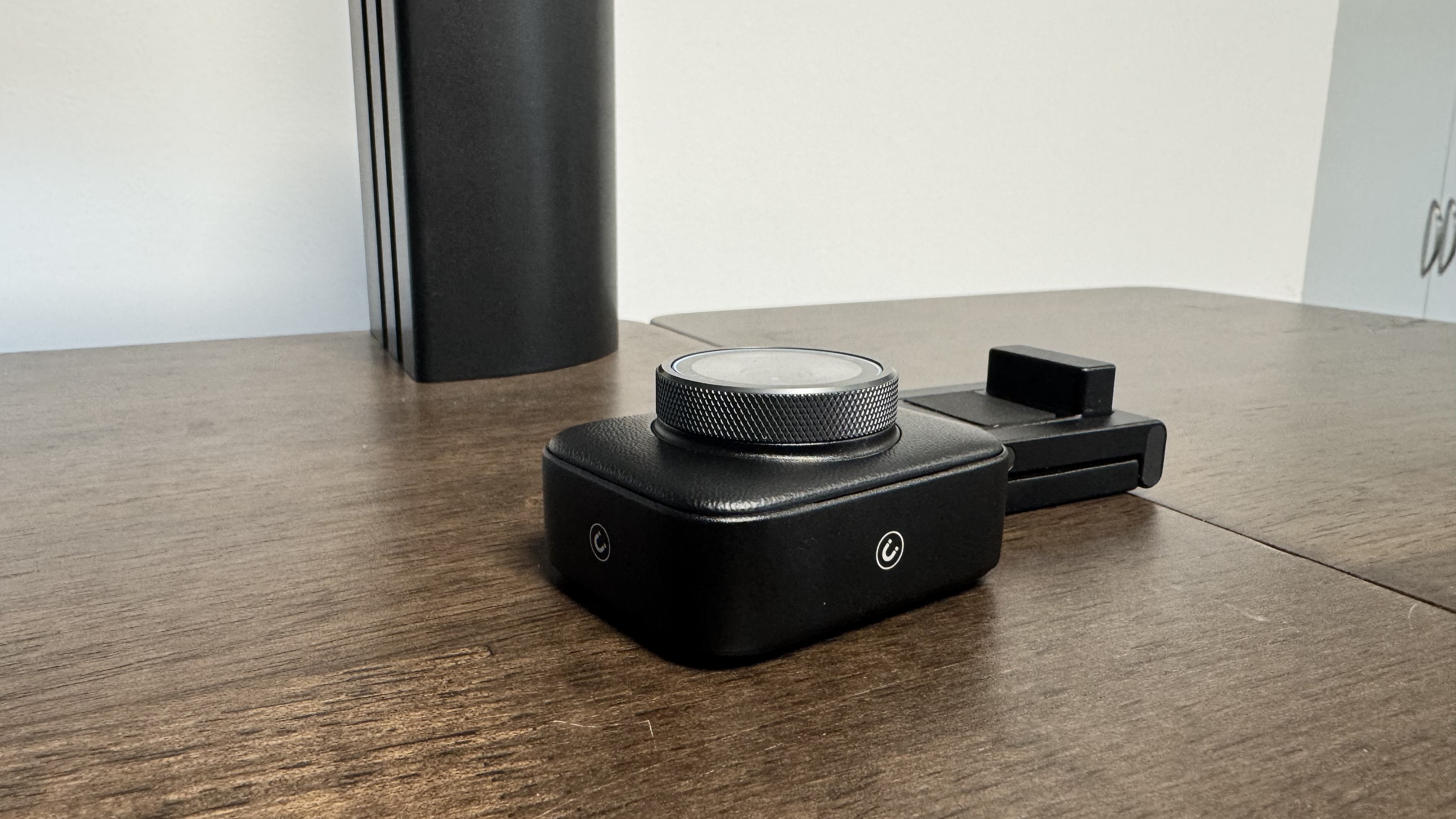 The Yololiv YoloCam S3 4K webcam from the bottom, next to its stand, on a wooden table