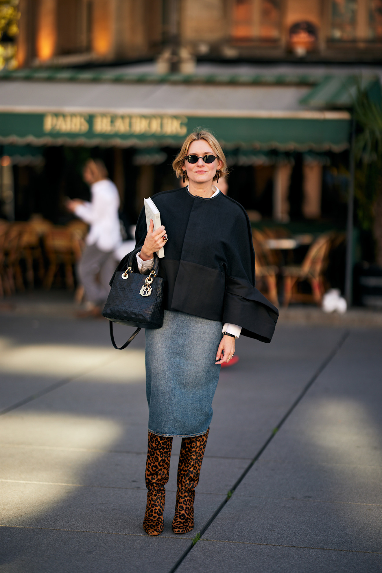 woman wearing a black sweater and denim skirt and leopard print boots