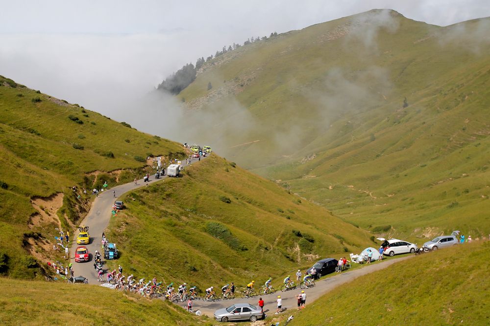 The peloton climbs out of the fog on the Port de Bales during stage 17 of the 2012 Tour de France from Bagneres-de-Luchon to Peyragudes.