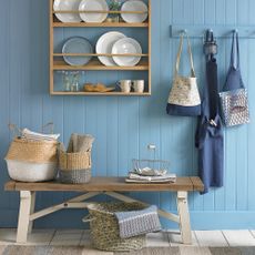 coastal kitchen with blue panel wall and shelve and bench