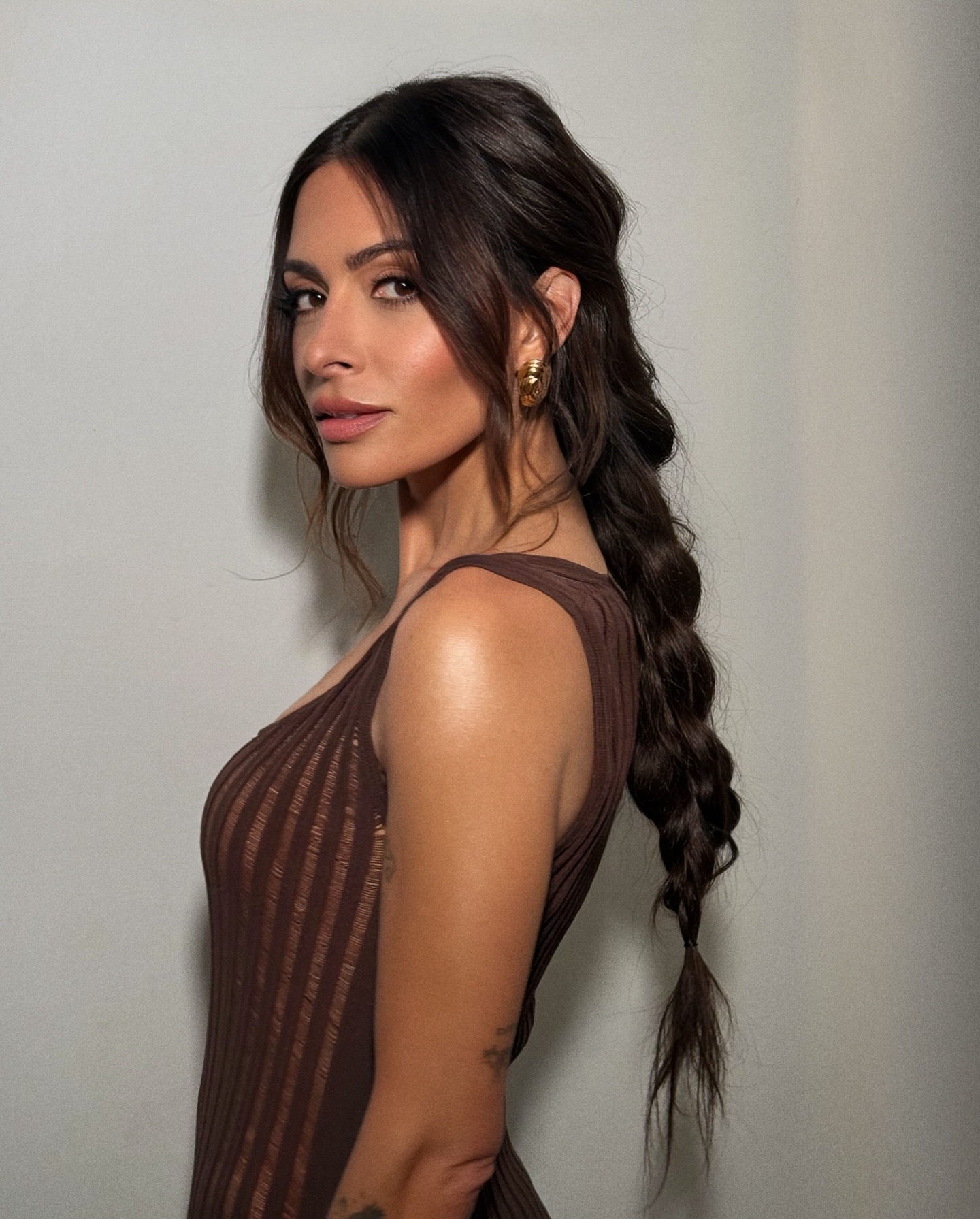 Sarah Shahi wears a loose fishtail braids with face-framing strands by Justine Marjan