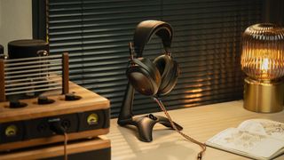 The new Meze Audio Liric 2nd Gen headphones on a stand on top of a desk