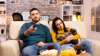 Couple watching movie with their cat