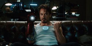 Robert Downey Jr sits on the couch testing a Repulsor glove in Iron Man.