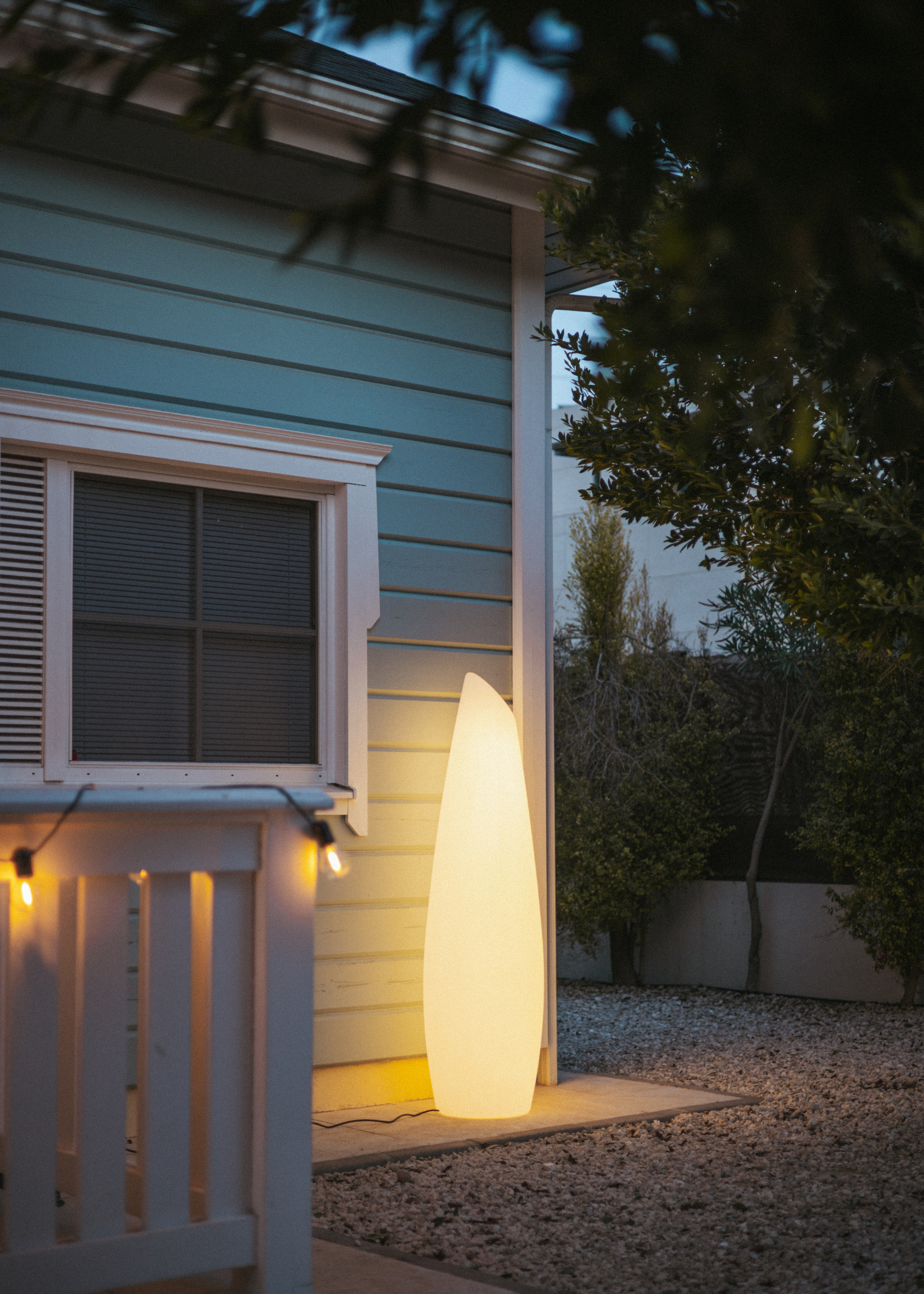 A structured tall floor lamp in an outdoor garden