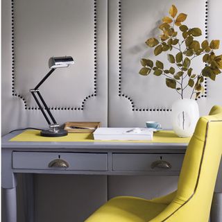 Yellow chair with leather desk and pot