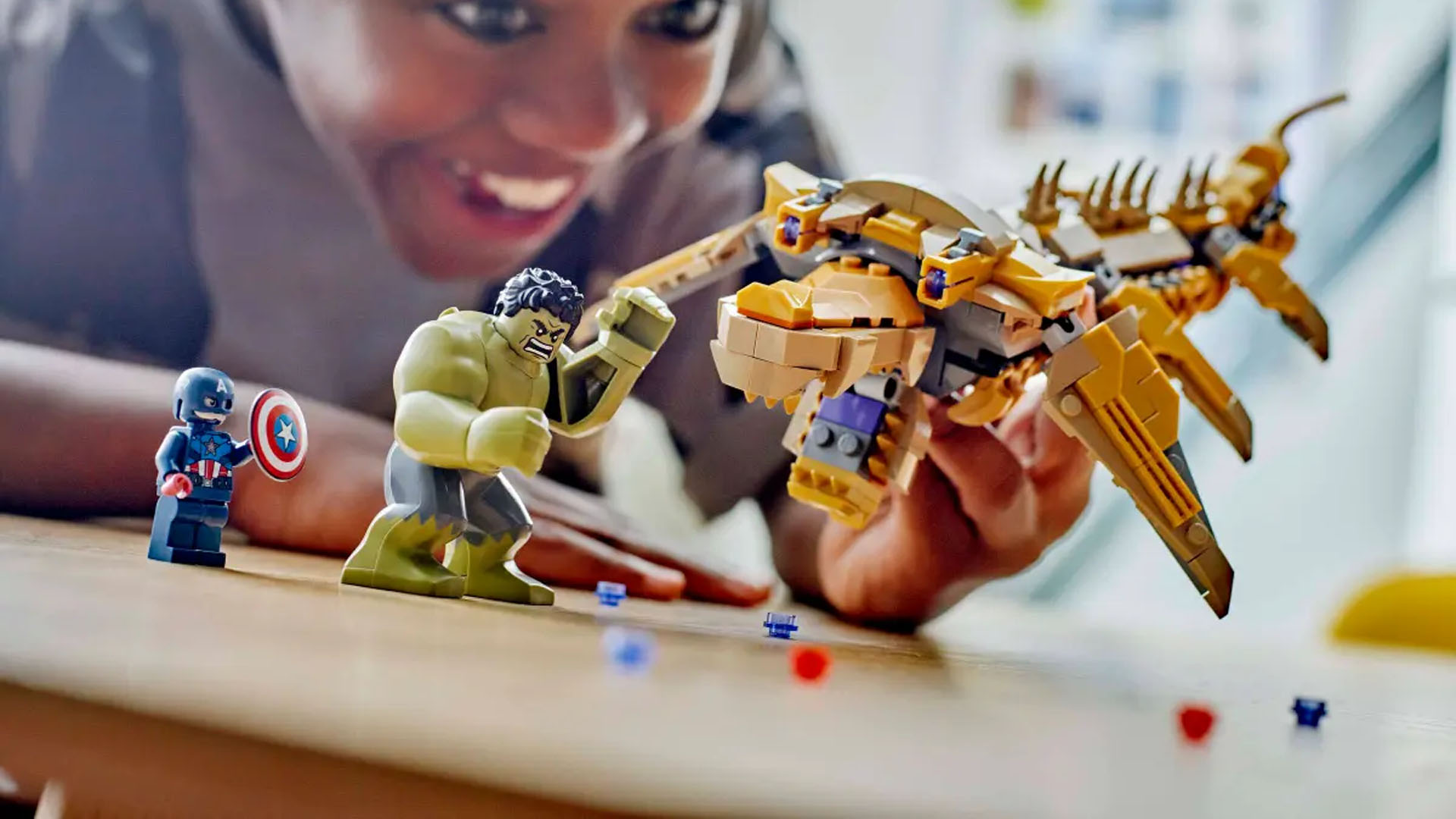 A child playing with the LEGO Marvel The Avengers vs. The Leviathan Superhero Toy, having the Hulk punch the Leviathan.
