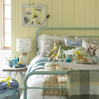 bedroom with primrose yellow wall and bed with pillows
