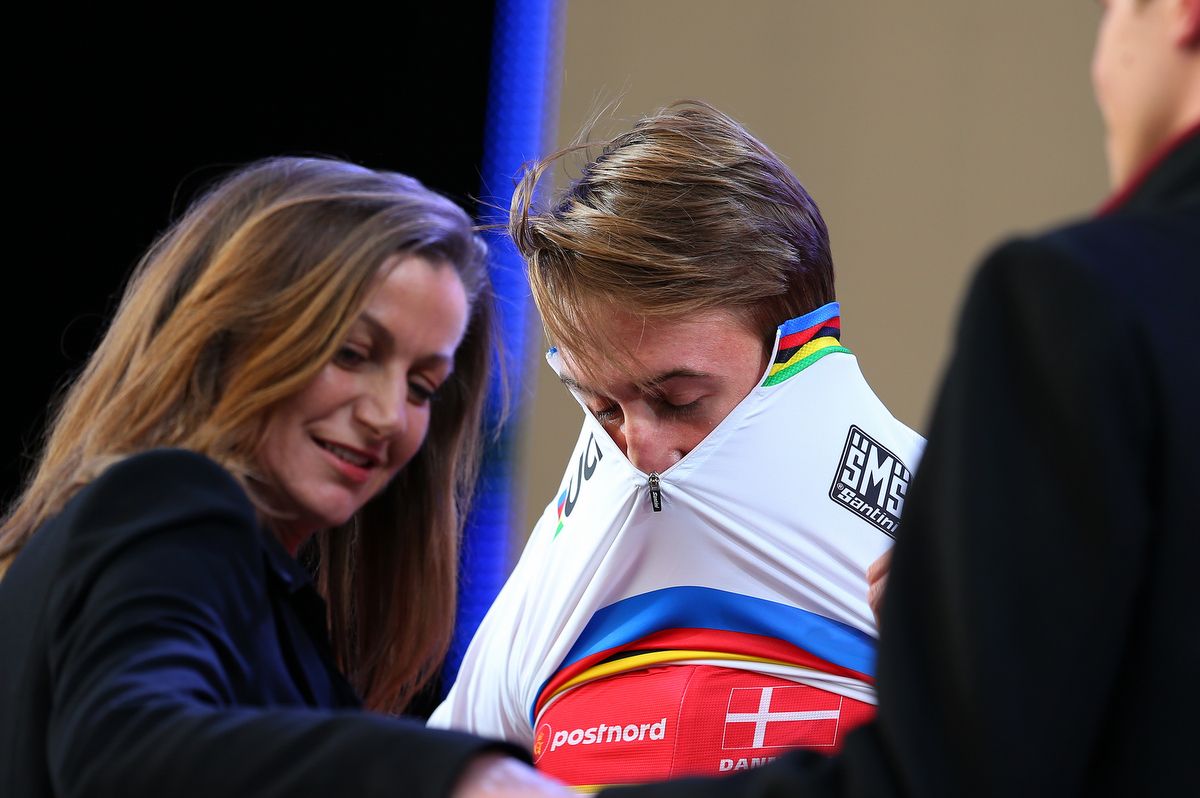 Mikkel Bjerg pulling on the rainbow jersey