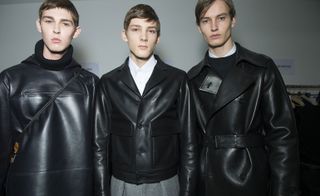 3 men wearing black at a fashion show