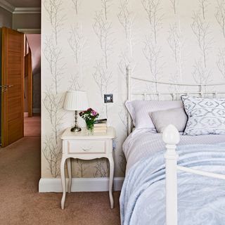 bedroom with printed wall and bed and bedside table