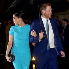 Prince Harry and Meghan Markle in March 2020 under an umbrella together