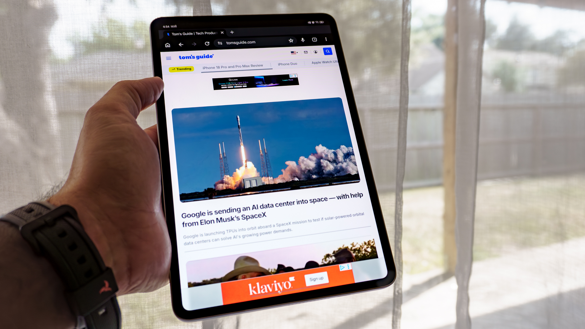 A person reading the Tom's Guide homepage on the RedMagic Astra 2 gaming tablet