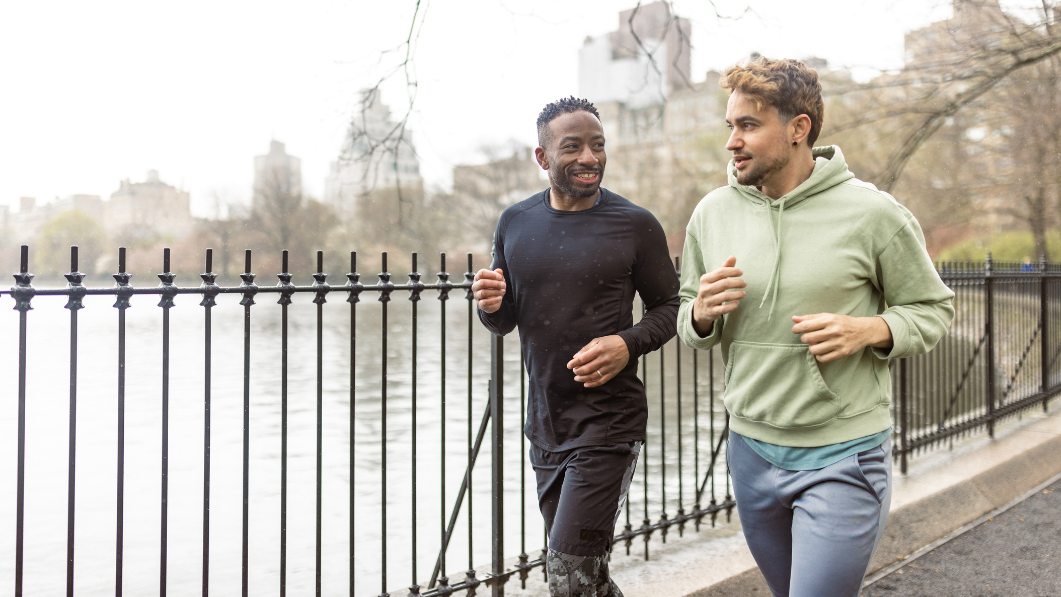 Two men running and talking around Central Park lake