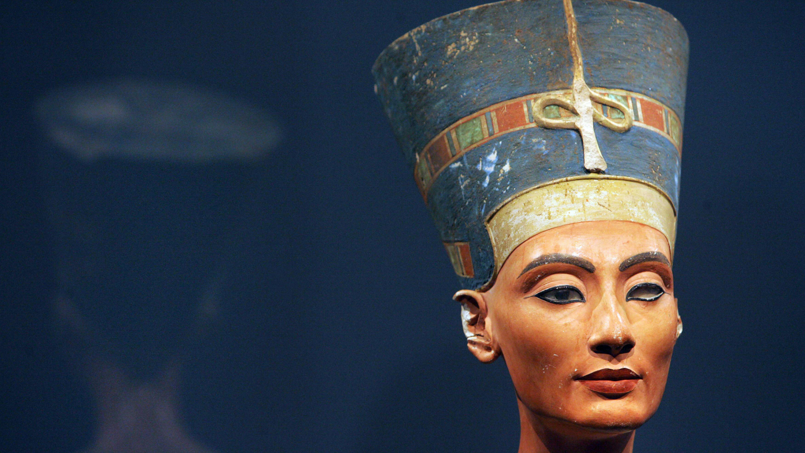 View of the bust of one of history's great beauties, Queen Nefertiti of Egypt. You can see her face and large blue and gold headdress.