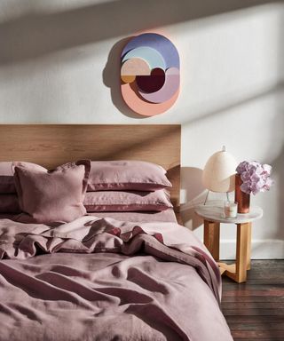 Lavender Flax Linen Bedding Bundle on a bed against a white wall.