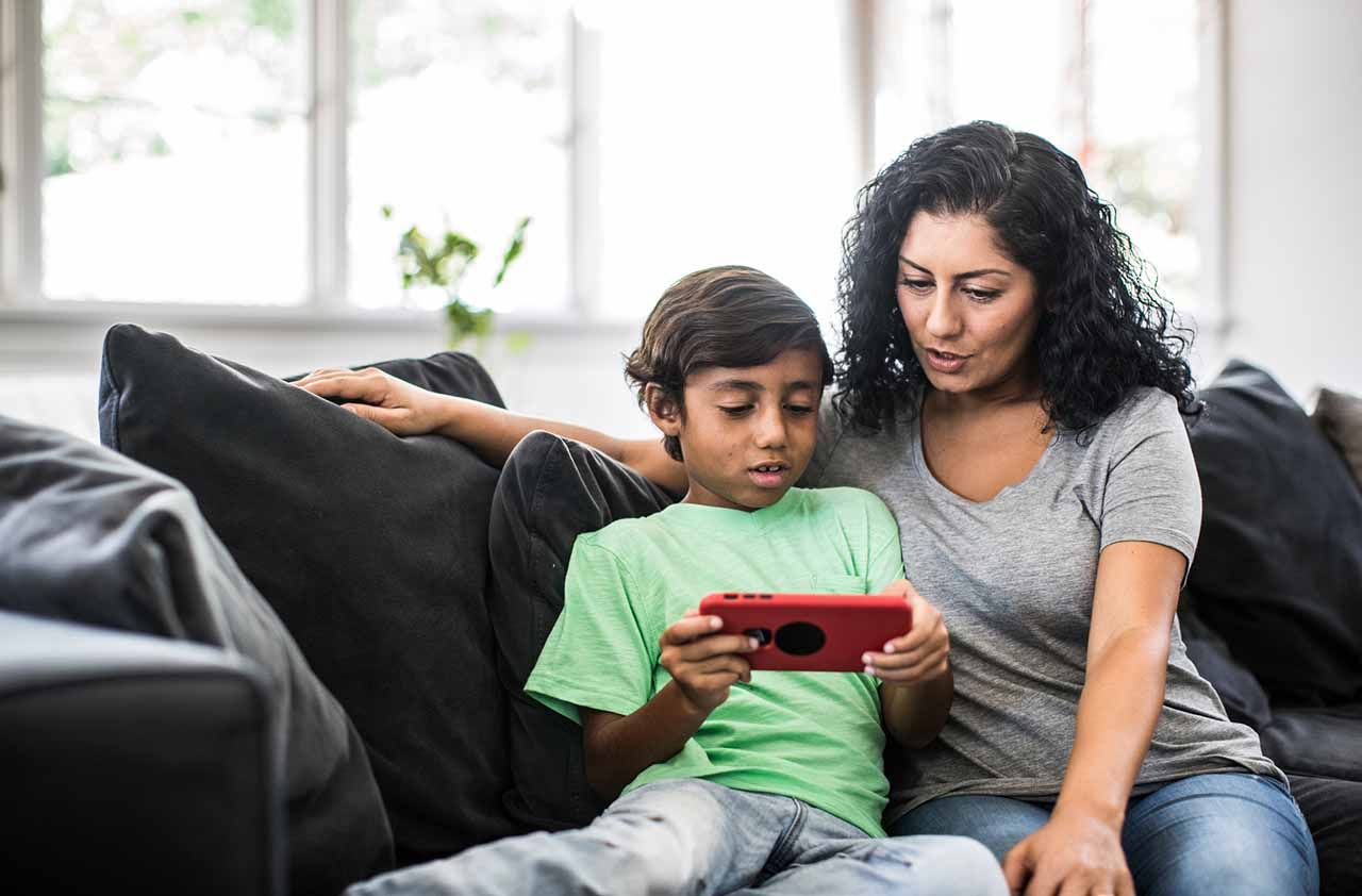 Mother and son looking at device at home