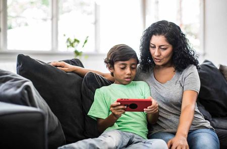 Mother and son looking at device at home