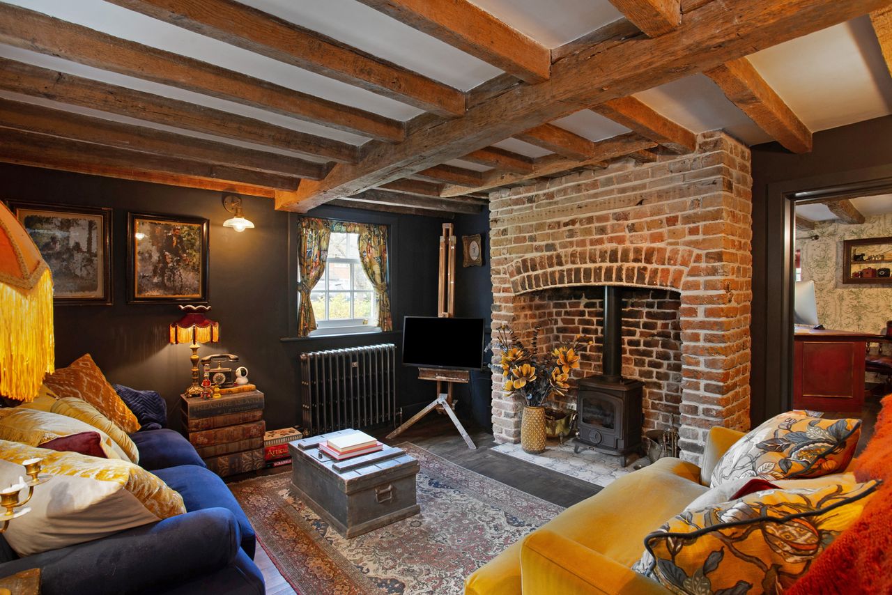 The dark green period sitting room with fire and sofas