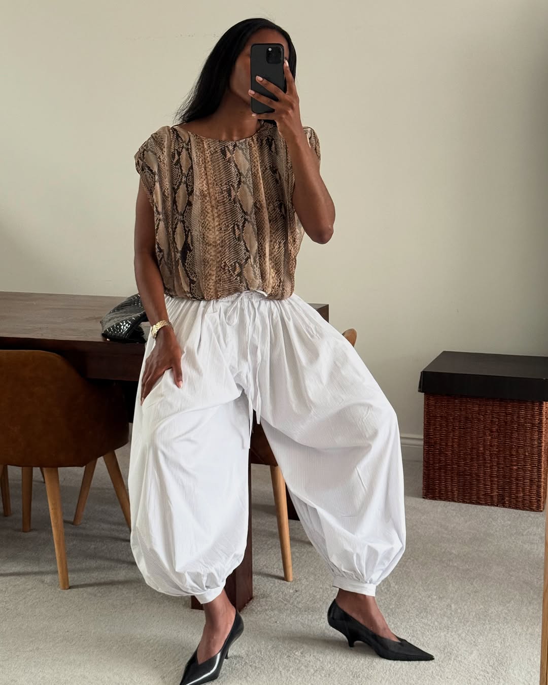 Influencer wearing poplin trousers and snake print top