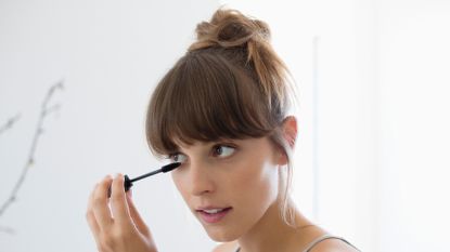 Close-up of a woman applying mascara - stock photo